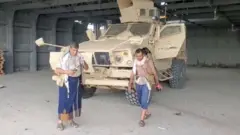 ክልተ ጀለብያ ዝገበሩ ዕጡቓት ሑቲ ኣብ ቅድሚ ሓንቲ ታንኪ